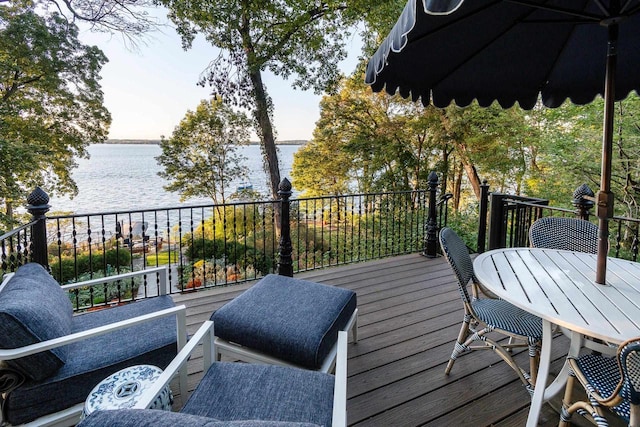 deck featuring a water view and outdoor dining space