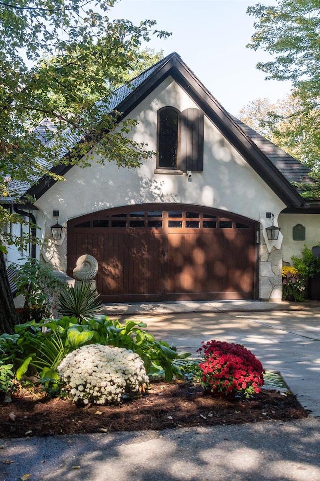 view of front of house with a garage, driveway, and stucco siding