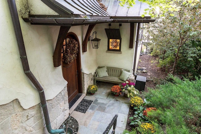 entrance to property featuring stucco siding and a standing seam roof