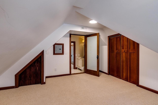 additional living space with visible vents, light colored carpet, and vaulted ceiling