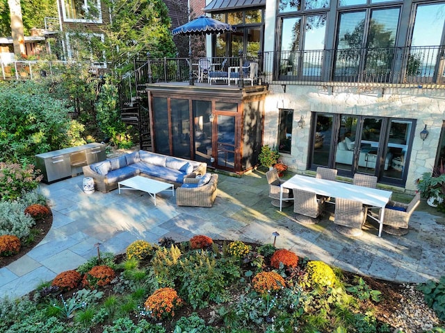 view of patio / terrace with outdoor dining area, a sunroom, an outdoor hangout area, and stairway