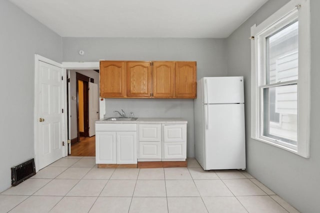 kitchen featuring sink, white fridge, and light tile patterned floors