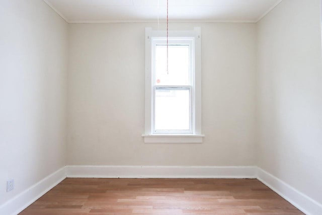 unfurnished room featuring a healthy amount of sunlight, hardwood / wood-style flooring, and crown molding