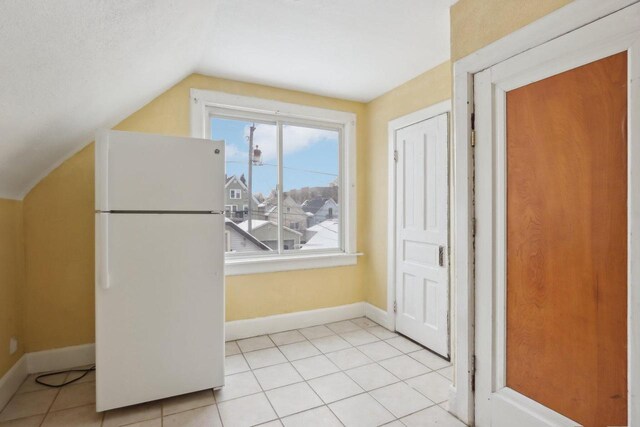 interior space featuring vaulted ceiling and light tile patterned floors