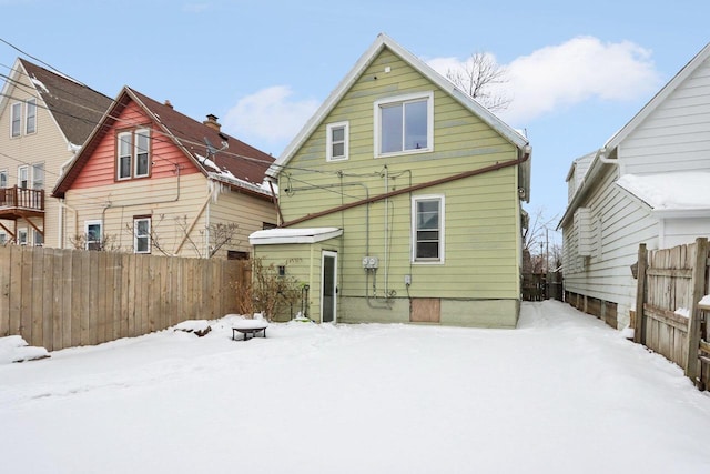 view of snow covered back of property