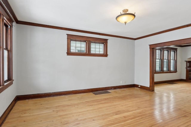 empty room featuring light hardwood / wood-style flooring and crown molding
