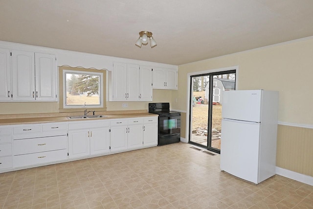 kitchen with white cabinetry, white fridge, sink, and black range with electric cooktop