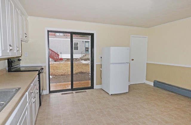 kitchen featuring white cabinetry, black electric range oven, crown molding, and white fridge