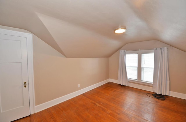 additional living space featuring wood-type flooring and vaulted ceiling