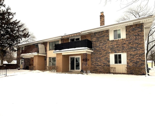 snow covered property featuring a balcony