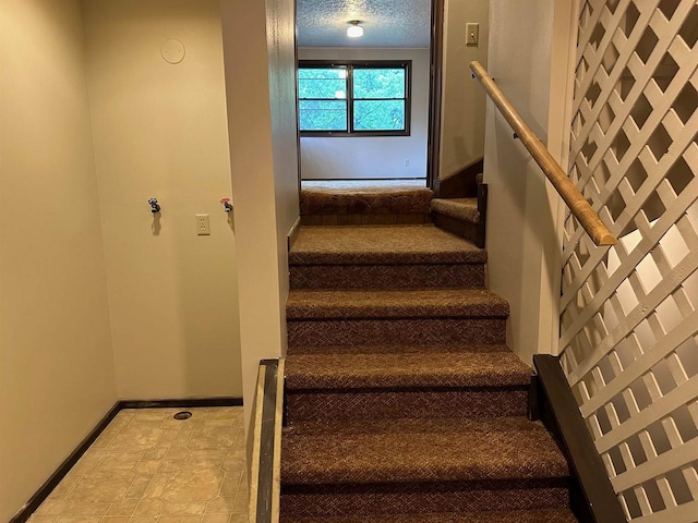 staircase with a textured ceiling