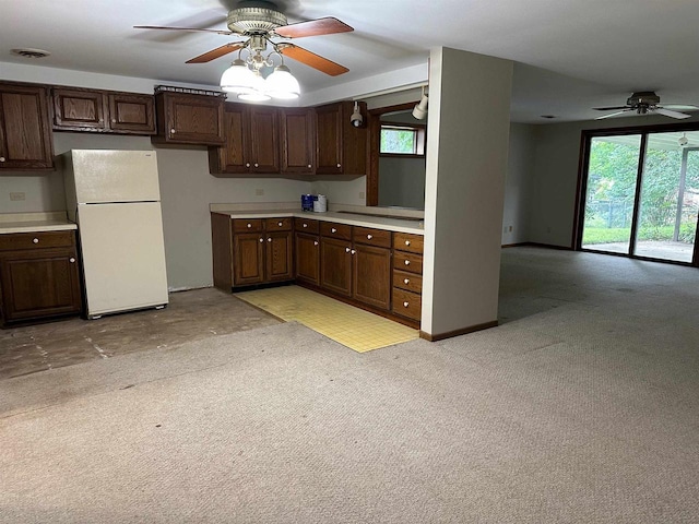 kitchen featuring white fridge, light colored carpet, and dark brown cabinetry