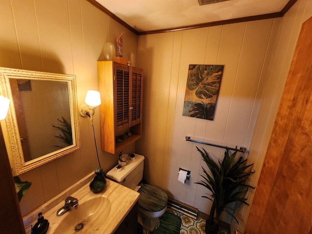 bathroom with ornamental molding, vanity, and toilet