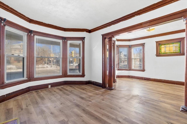 unfurnished room with light wood-type flooring, ornate columns, and ornamental molding