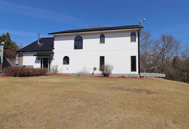 view of front of home featuring metal roof and a front yard