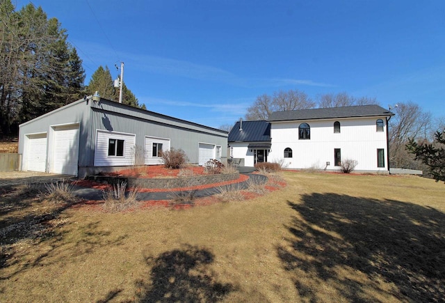 back of house featuring a yard and a garage