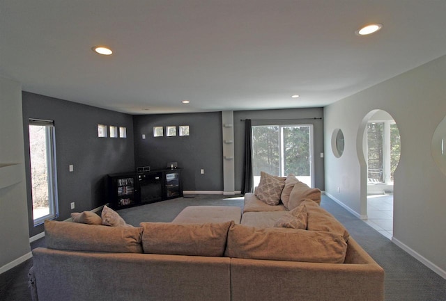 carpeted living room featuring recessed lighting, baseboards, and arched walkways