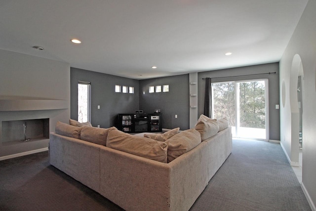 carpeted living room with plenty of natural light, recessed lighting, a fireplace, and baseboards