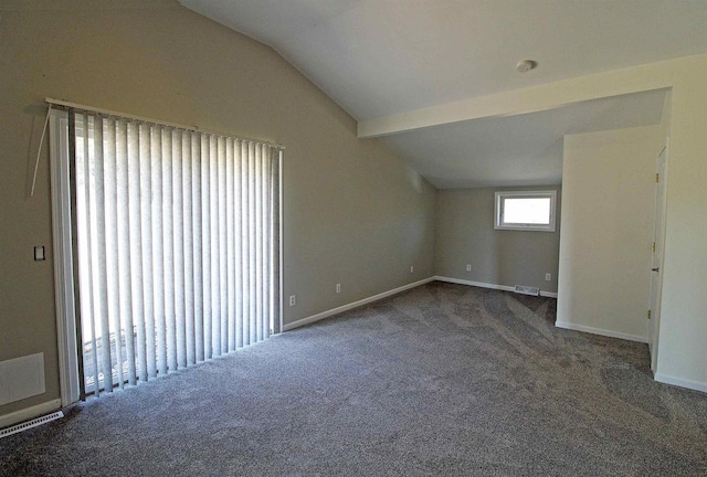 carpeted spare room with baseboards and vaulted ceiling