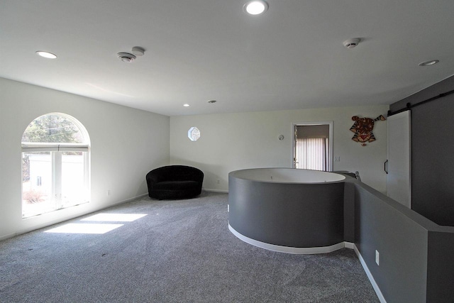 interior space featuring recessed lighting, baseboards, a barn door, and carpet floors