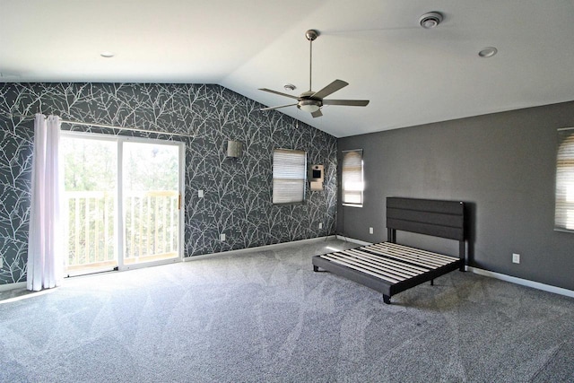 unfurnished bedroom with wallpapered walls, lofted ceiling, carpet, and baseboards