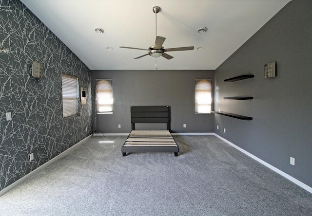 unfurnished bedroom featuring visible vents, baseboards, wallpapered walls, vaulted ceiling, and carpet flooring