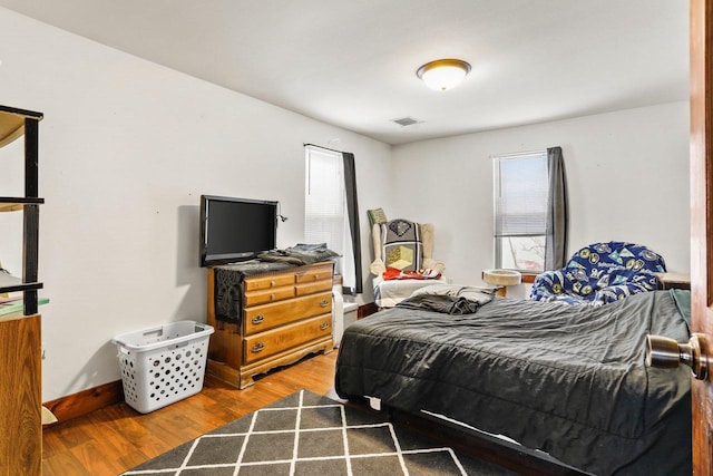 bedroom with dark hardwood / wood-style flooring