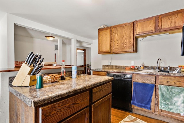 kitchen featuring light hardwood / wood-style floors, black dishwasher, and sink