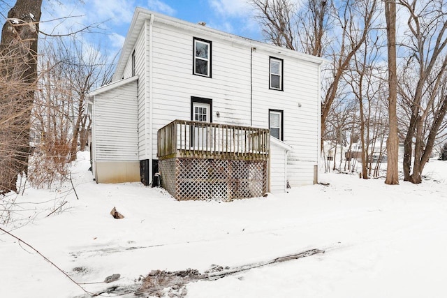 snow covered house featuring a wooden deck