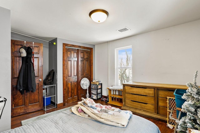 bedroom with dark hardwood / wood-style flooring and a closet