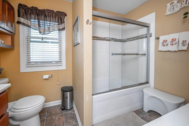 full bathroom featuring vanity, bath / shower combo with glass door, and toilet