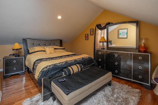 bedroom with hardwood / wood-style flooring and vaulted ceiling