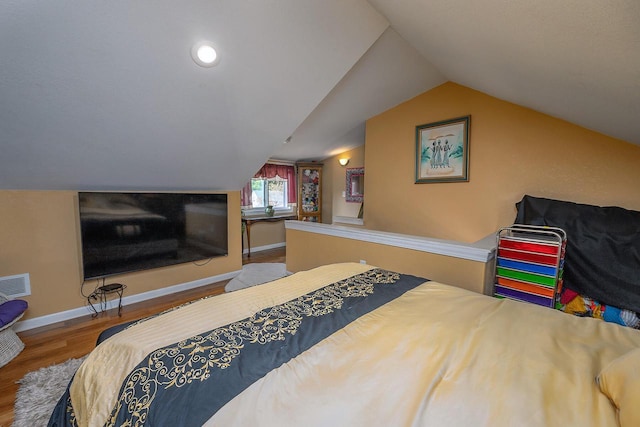 bedroom with vaulted ceiling and hardwood / wood-style floors