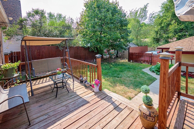 wooden deck featuring a lawn