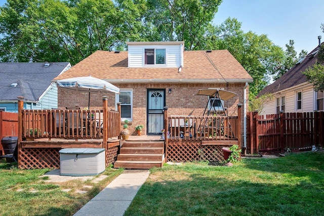 rear view of property featuring a yard and a deck