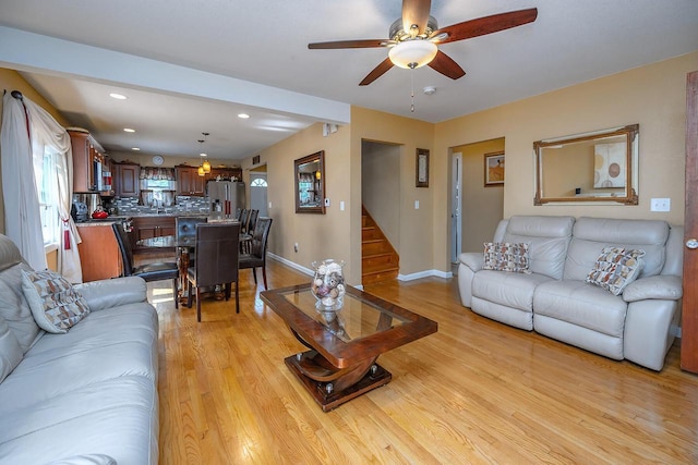 living room featuring ceiling fan and light hardwood / wood-style flooring