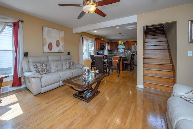 living room with light hardwood / wood-style flooring and ceiling fan