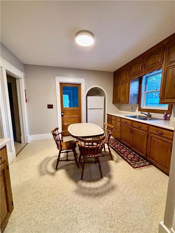 dining area featuring light carpet and sink