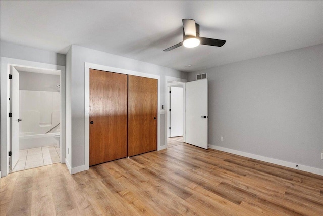 unfurnished bedroom featuring ceiling fan, light hardwood / wood-style flooring, connected bathroom, and a closet