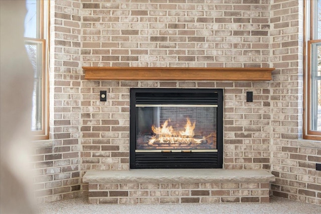 room details featuring carpet floors and a brick fireplace