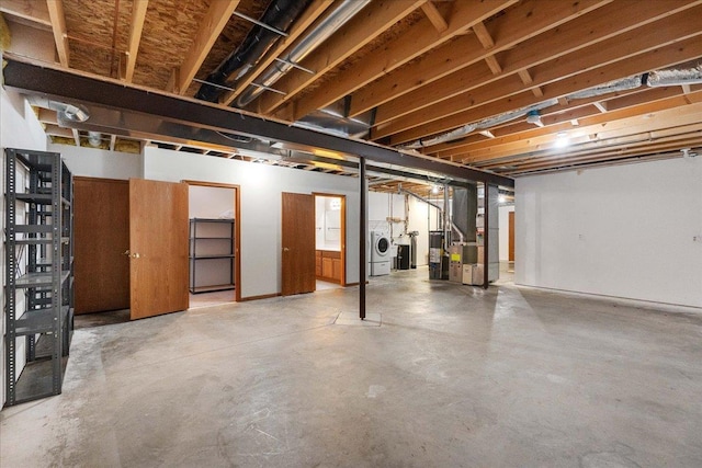 basement featuring heating unit and separate washer and dryer