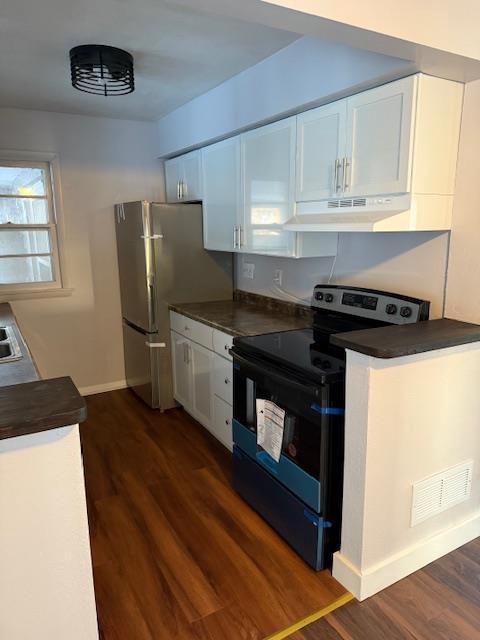 kitchen featuring electric stove, stainless steel fridge, dark hardwood / wood-style floors, and white cabinets