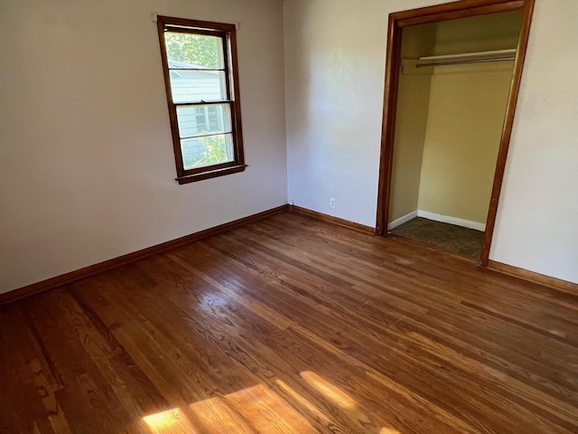 unfurnished bedroom featuring dark wood-type flooring and a closet