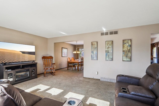 carpeted living room with a notable chandelier