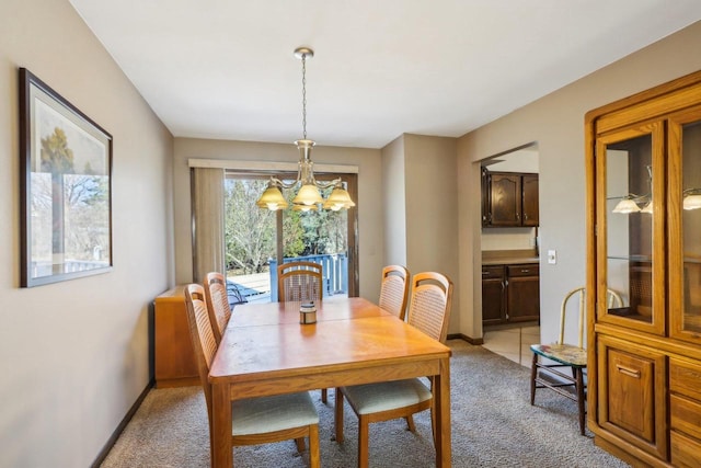 carpeted dining space featuring a notable chandelier