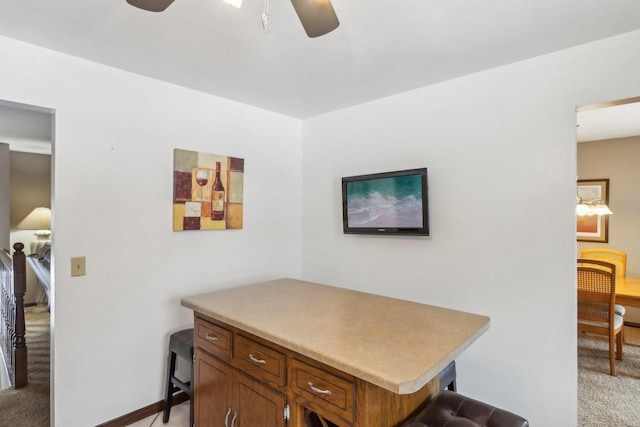 carpeted office space featuring ceiling fan