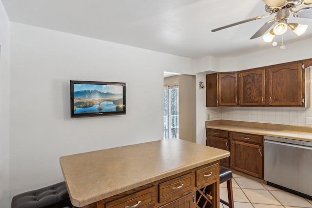 kitchen with tasteful backsplash, stainless steel dishwasher, ceiling fan, and light tile patterned floors