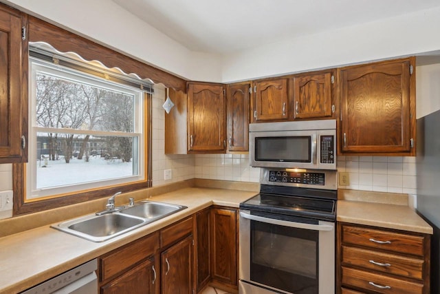 kitchen featuring appliances with stainless steel finishes, sink, and decorative backsplash