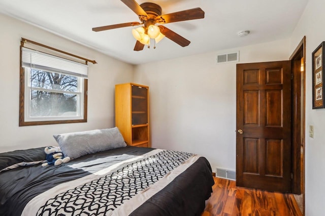 bedroom with dark hardwood / wood-style floors and ceiling fan