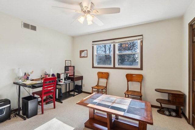 carpeted office space featuring ceiling fan